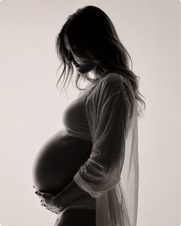 Silhouette in controluce di una donna incinta che tiene il pancione